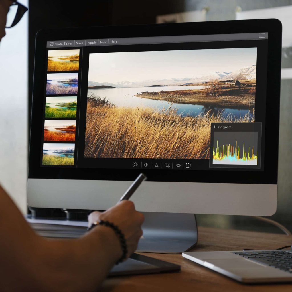 Graphic designer using Adobe Photoshop to edit and enhance a landscape image.